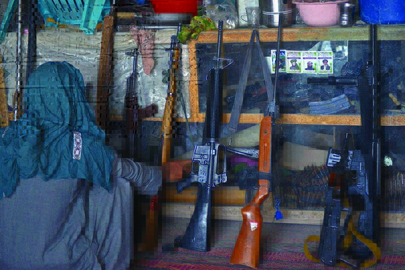 PANJWAI, Afghanistan: An Afghan vendor displays guns for sale as he waits for customers in his shop at a market in this district of Kandahar province on Saturday. - AFP n