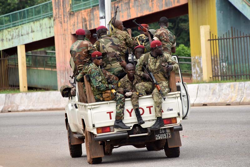 CONAKRY: Members of the armed forces of Guinea drive through the central neighborhood of Kaloum yesterday. – AFP n