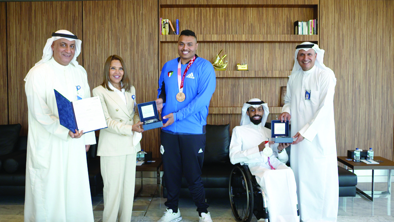 KUWAIT: NBK officials honor Paralympic champions Ahmad Naqa Al-Mutairi and Faisal Sorour.n