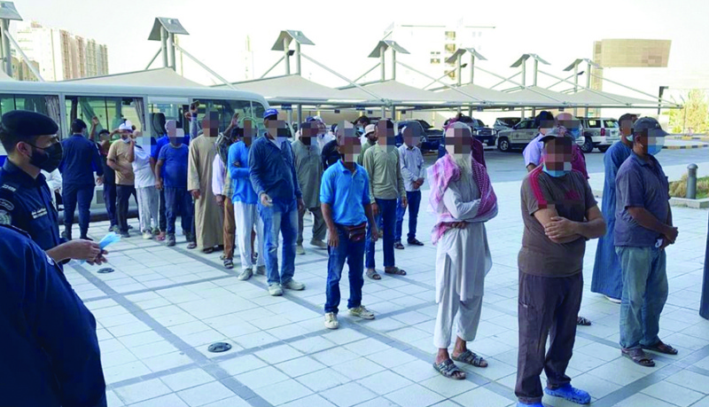KUWAIT: This handout photo released by the Interior Ministry yesterday shows people lined up during a police crackdown in Jahra. n