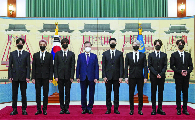 This picture shows South Korean President Moon Jae-in (fourth left) posing with members of K-pop sensation BTS as they receive diplomatic passports for a UN session as presidential special envoys at the presidential Blue House in Seoul. –AFP photosn