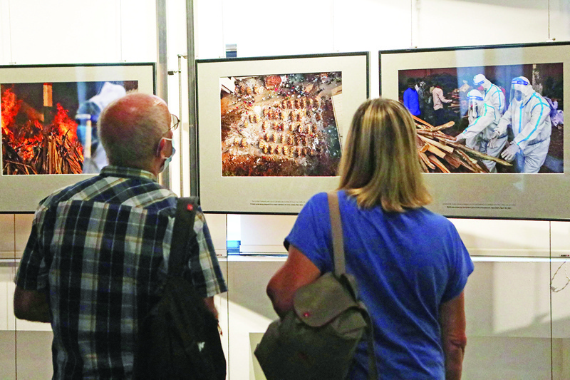 Visitors look at photos displayed at the exhibition “Documenting India’s Greatest Healthcare Crisis” by Indian Reuters photographer Danish Siddiqui during the 33rd edition of the Visa pour l’Image international photojournalism festival, in Perpignan, southern France, on September 3, 2021.—AFP photosn
