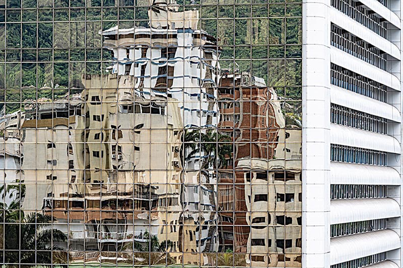 CARACAS: Apartment buildings are reflected in the windows of another one in the middle class neighborhood of Los Palos Grandes in Caracas.-AFP