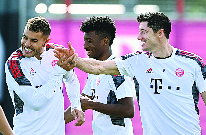 MUNICH: (From left) Bayern Munich's French defender Lucas Hernandez, French defender Kingsley Coman and Polish striker Robert Lewandowski joke during a training session on the eve of the first UEFA Champions League Group E football match against Barcelona at the clubs training ground in Munich, southern Germany, yesterday. - AFPn