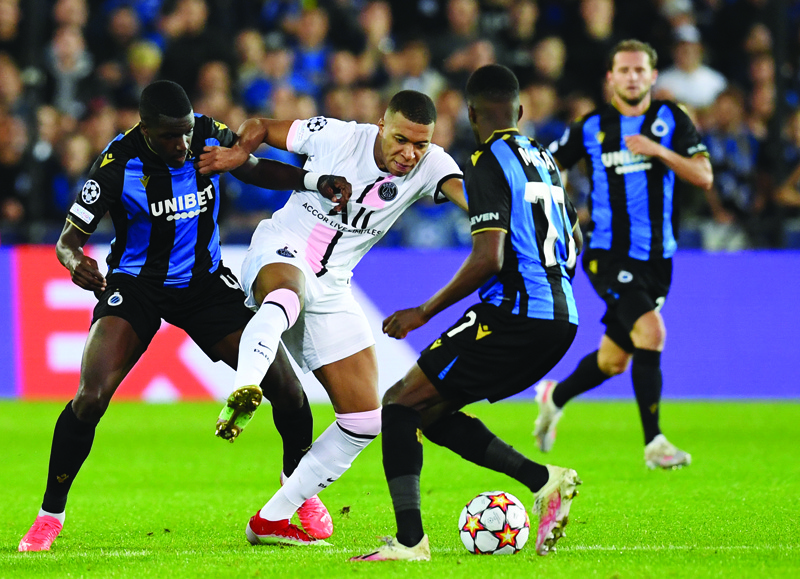 BRUGES: Paris Saint-Germain's French forward Kylian Mbappe (center) fights for the ball with Club Brugge's French defender Stanley Nsoki (left) and Angolan defender Clinton Mata during the UEFA Champions League Group A football match between Club Brugge and Paris Saint-Germain at Jan Breydel Stadium in Bruges, on Wednesday. - AFPn