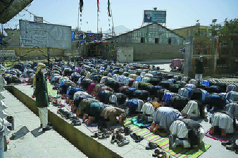KABUL: Members of the Hazara community offer prayer outside a mosque on the outskirts of Kabul. —AFP