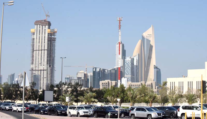 KUWAIT: Vehicles stopped at a traffic light as Kuwait City high-rise buildings are seen in the background. - Photo by Fouad Al-Shaikh