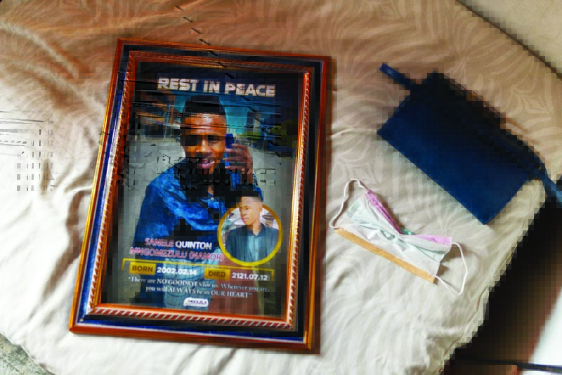INANDA: A picture of Sanele Mngomezulu, 19, who was shot during the wave of violence in South Africa last July, lays on a bed in Inanda, South Africa. - AFP n