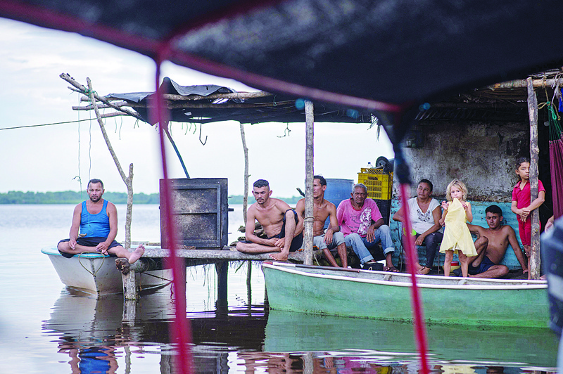 OLOGA: A family rests at the entrance of their stilt home over the Maracaibo Lake in Ologa, Zulia state, Venezuela. - AFP n