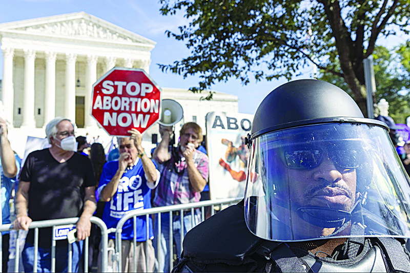 WASHINGTON: United States Capitol Police in riot gear stand between Women rights activists and anti-abortion activist, as they gather in front of the supreme court after a rally at freedom plaza for the annual Women's March. - AFP n