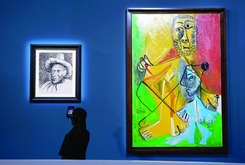 A guest takes a personal photograph of Spanish artist Pablo Picasso’s “Pierrot,” (left) near “Homme et enfant” before the start of a Sotheby’s auction of 11 works by Pablo Picasso from the MGM Resorts Fine Art Collection in Las Vegas.—AFP photos   n