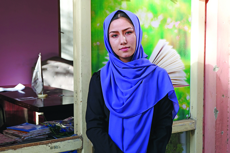 This picture shows school teacher Nasrin Hasani posing for pictures during an interview with AFP in Kabul.—AFP photosn