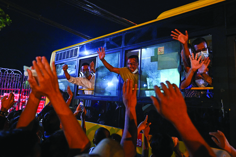 YANGON: Newly-released prisoners wave from a bus as they depart the Insein Prison in Yangon yesterday after authorities announced more than 5,000 people jailed for protesting against a February coup which ousted the civilian government would be released. - AFP n