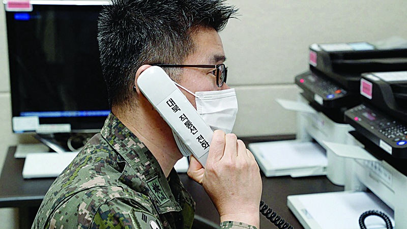 SEOUL: This handout photo taken and provided by South Korea's Defense Ministry in Seoul shows a South Korean military officer speaking over a phone call with a North Korean official at an undisclosed location near the Demilitarized Zone (DMZ) dividing the two Koreas after North and South Korea restored their cross-border communications. - AFPn