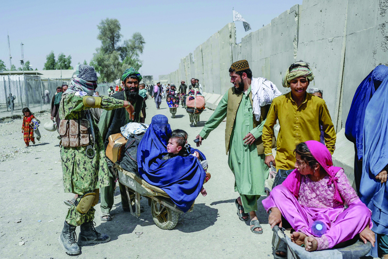 KANDAHAR: People with their belongings rush to pass to Pakistan from the Afghanistan border in Spin Boldak. - AFP n