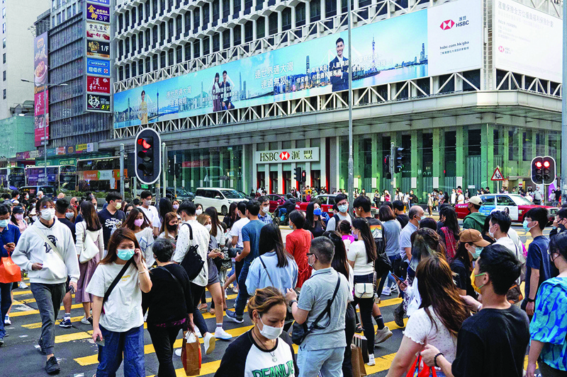 HONG KONG: Pedestrians cross a street in Hong Kong yesterday. - AFP n