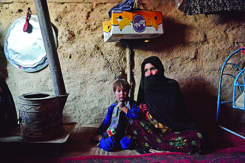QALA I NAW: Sabehreh (right) with her daughter Zakereh, who is betrothed to the grocer's four-year-old son to cover the family's debt, sits at the Zaimat Internally Displaced People (IDP) camp in Qala-i-Naw, Badghis Province. - AFP n