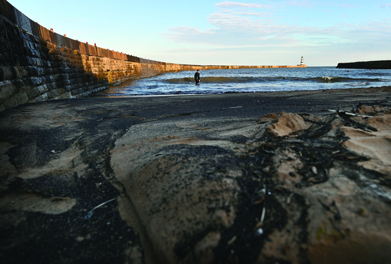 SEAHAM, UK: Coal dust is washed up on the beach at Seaham Harbor in Seaham, northeast England.-AFPnnn