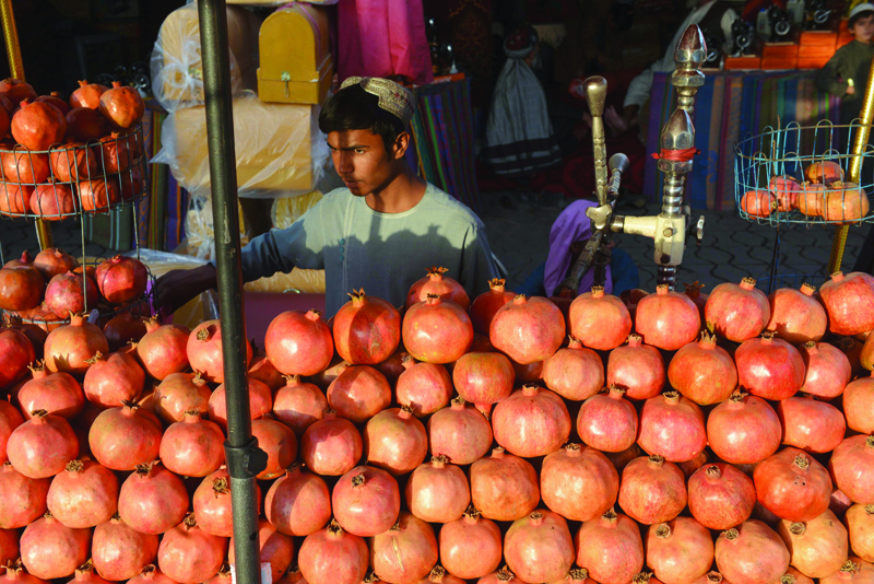 KANDAHAR: A vendor selling pomegranate juice waits for customers at his stall in Kandahar.-AFPnn