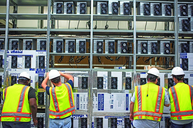 ROCKDALE, US: Workers install a new row of Bitcoin mining machines at the Whinstone US Bitcoin mining facility in Rockdale, Texas.-AFPnn