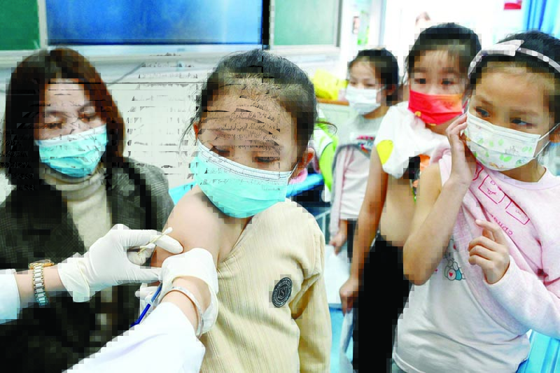 HANDAN: A child receives the COVID-19 coronavirus vaccine at a school in Handan, in China's northern Hebi province yesterday, after the city began vaccinating children between the ages of 3 to 11. - AFP n