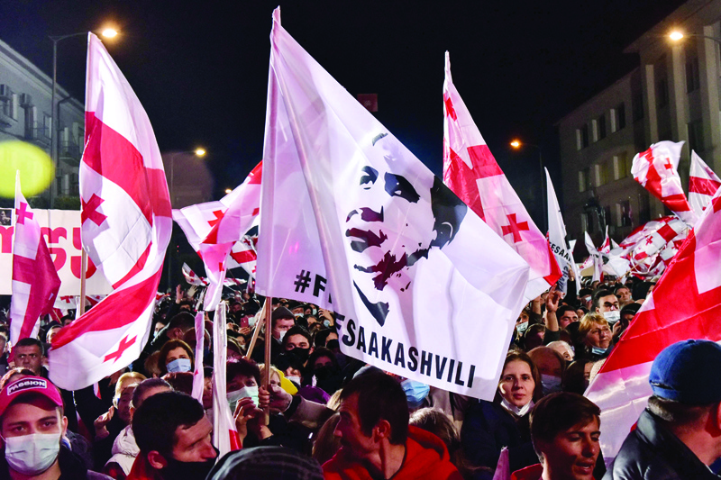 ZUGDIDI, Georgia: People hold banners and wave flags during a rally in the city of Zugdidi, about 300 km from the capital Tbilisi, yesterday, to demand the release from jail of their ex-president and opposition leader Mikheil Saakashvili. - AFPnn