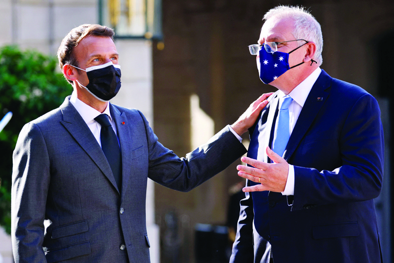 PARIS: File photo shows French President Emmanuel Macron greets Australia's Prime Minister Scott Morrison at the Elysee Palace in Paris. French President Emmanuel Macron spoke with Australian Prime Minister Scott Morrison by telephone yesterday for the first time since the diplomatic crisis over a scrapped submarine deal last month. - AFPnn