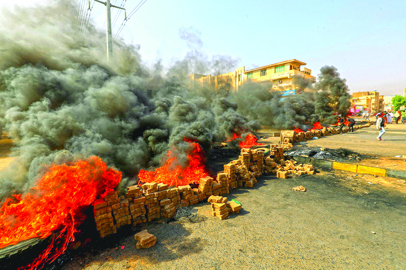 KHARTOUM: Sudanese protesters use bricks and burning tyres to block 60th Street in the capital Khartoum, to denounce overnight detentions by the army of members of Sudan's government yesterday. – AFP n