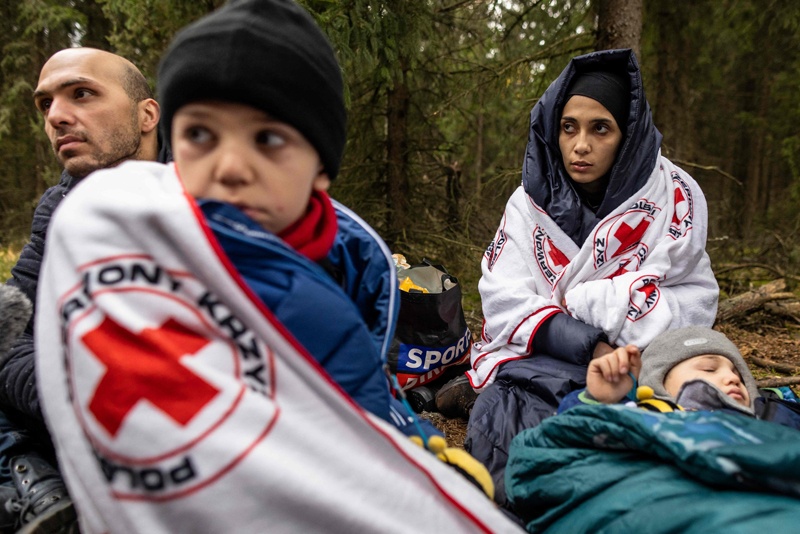 KLESZCZELE, Poland: The Massini family from Syria, father Muhammad (L), mother Alaa (C) and their two sons are seated while awaiting transport in the forest near the east Polish town of Kleszczele. Thousands of migrants, mostly from the Middle East have crossed or tried to cross from Belarus since the summer. – AFPnn