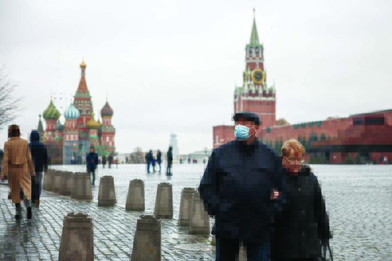 MOSCOW: An elderly couple walk across Red Square amid the outbreak of the COVID-19 pandemic in Moscow yesterday. Russia reported record numbers of daily coronavirus cases and deaths. - AFPnn