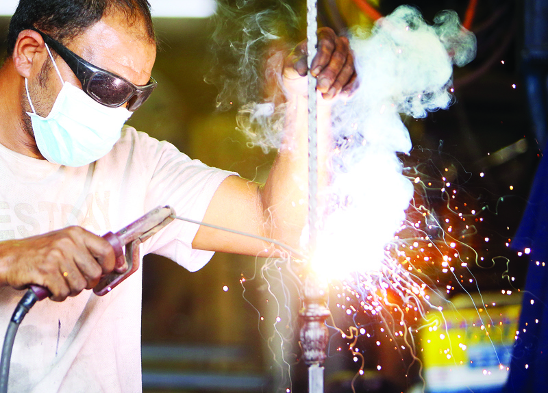 KUWAIT: A welder works at a metal workshop in this file photo. - Photo by Yasser Al-Zayyatn