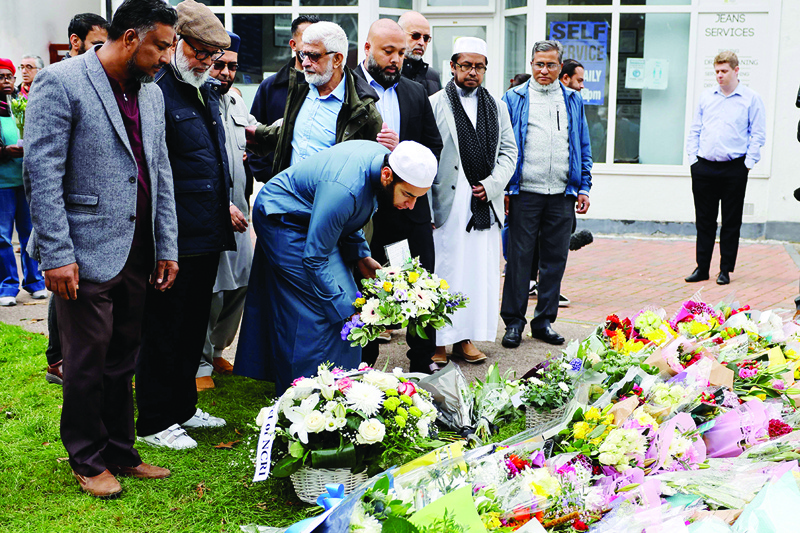 LEIGH-ON-SEA: Members of the Muslim community lay floral tributes at the scene of the fatal stabbing of Conservative British lawmaker David Amess at Belfairs Methodist Church in this district of Southend-on-Sea in southeast England yesterday. - AFP n