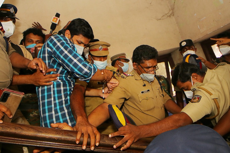 KOLLAM, India: Police take Sooraj Kumar into custody after he was sentenced to life in jail for murdering his wife with a snake yesterday. - AFP n
