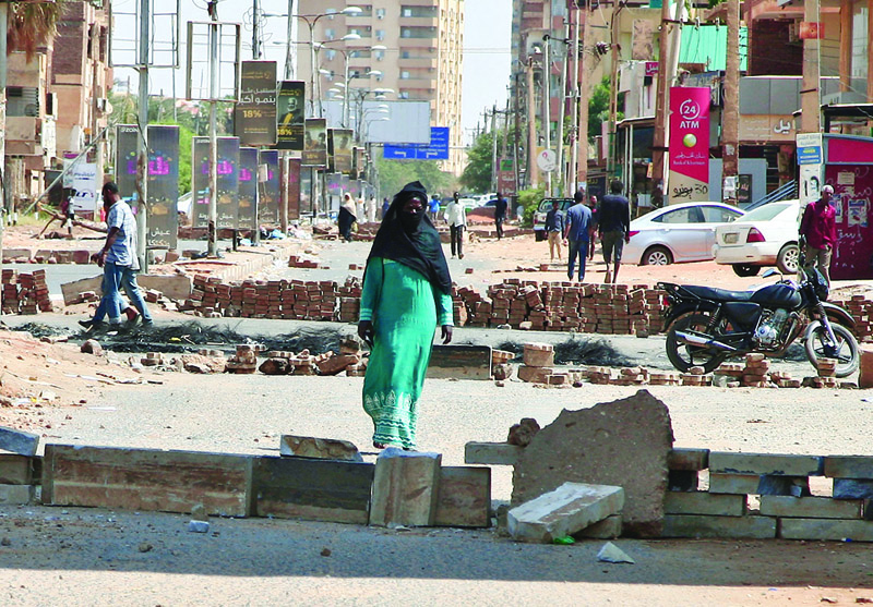 KHARTOUM: Sudanese anti-coup protesters use bricks to barricade a street in the capital yesterday. – AFP n