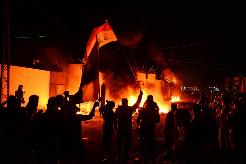 NAJAF: In this file photo taken on Nov 28, 2019, Iraqi demonstrators gather as flames start consuming Iran's consulate in this southern Shiite holy city. - AFP  nnn