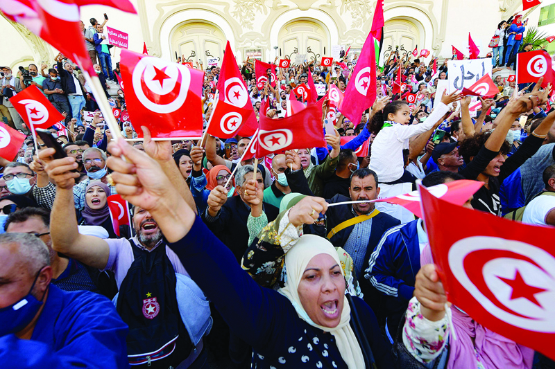 TUNIS: Tunisians rally against the president along Habib Bourguiba Avenue in the capital yesterday. - AFP n