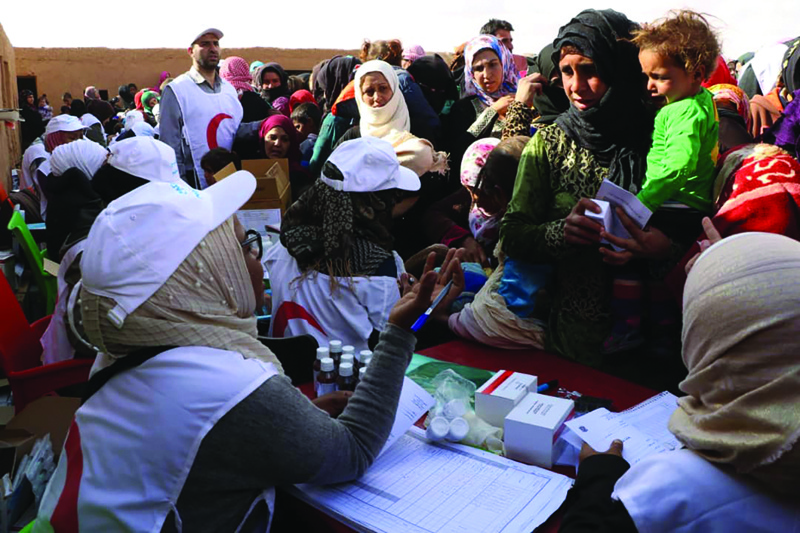 RUKBAN: In this handout file photo released by the Syrian Arab Red Crescent (SARC) on November 5, 2018, displaced people receive vaccinations at the Rukban desert camp for displaced Syrians along Syria's border with Jordan. - AFPn