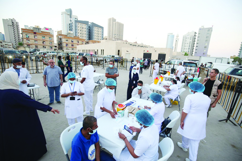 KUWAIT: People receive their COVID-19 vaccines during a mass vaccination campaign in the Bneid Al-Gar district of Kuwait City yesterday. - Photos by Yasser Al-Zayyatn