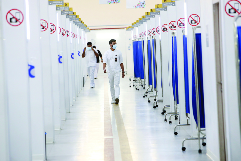 KUWAIT: Medical workers, wearing face masks, walk at the Kuwait Vaccination Center in Mishref yesterday. - Photos by Yasser Al-Zayyatn