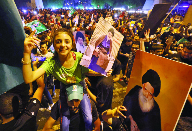 BAGHDAD: Supporters of Iraqi Shiite cleric Moqtada Al-Sadr celebrate in Baghdad's Tahrir square on October 11, 2021 following the announcement of parliamentary elections' results. - AFP n