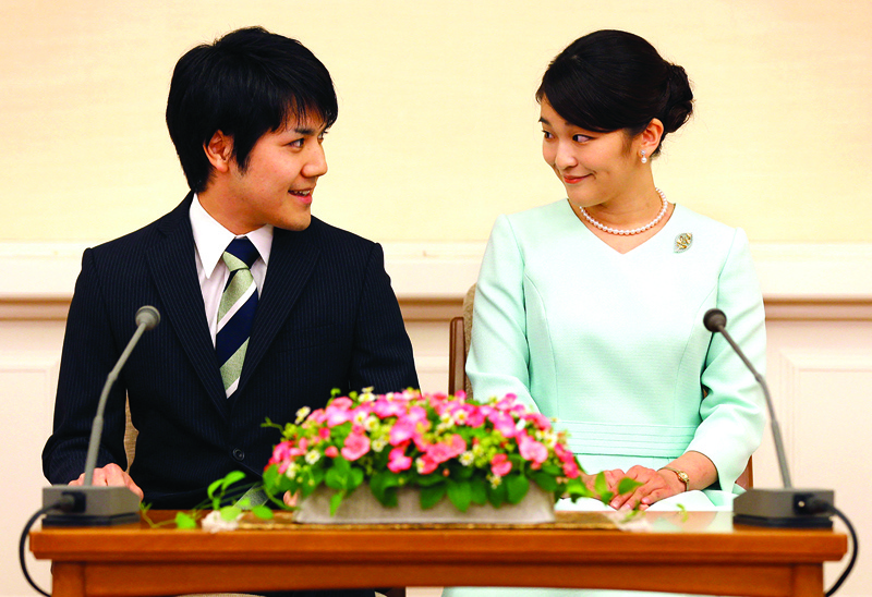 File photo shows Japan's Princess Mako (R), the eldest daughter of Prince Akishino and Princess Kiko, looking at her fiancee Kei Komuro (L), as they meet the media during a press conference to announce their engagement at the Akasaka East Residence in Tokyo. - AFPnn