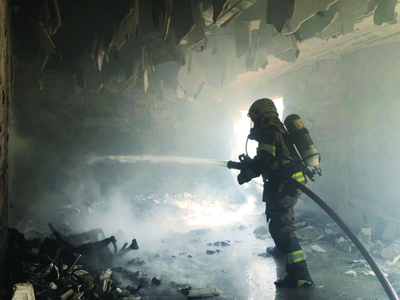 KUWAIT: A fireman battles a blaze inside a Salmiya building yesterday.n