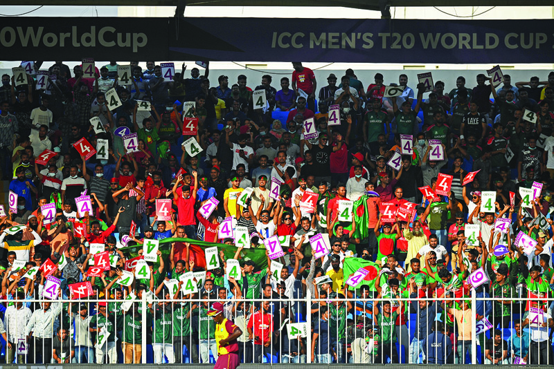 SHARJAH: Fans of Bangladesh's team cheer during the ICC men's Twenty20 World Cup cricket match between Bangladesh and West Indies at the Sharjah Cricket Stadium in Sharjah on Friday. - AFPn