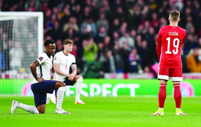 LONDON: England's midfielder Raheem Sterling (left) and defender John Stones take the knee in support of the No Room For Racism campaign, ahead of the FIFA World Cup 2022 qualifying match between England and Hungary at Wembley Stadium in London on Tuesday. - AFPn