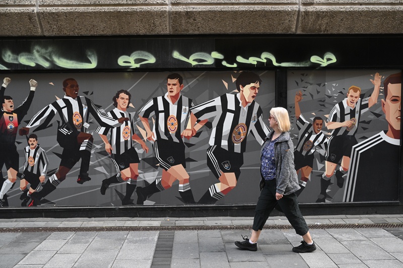 NEWCASTLE: A pedestrian passes a Newcastle United football club-themed mural in Newcastle upon Tyne in northeast England on October 8, 2021. – AFPnn