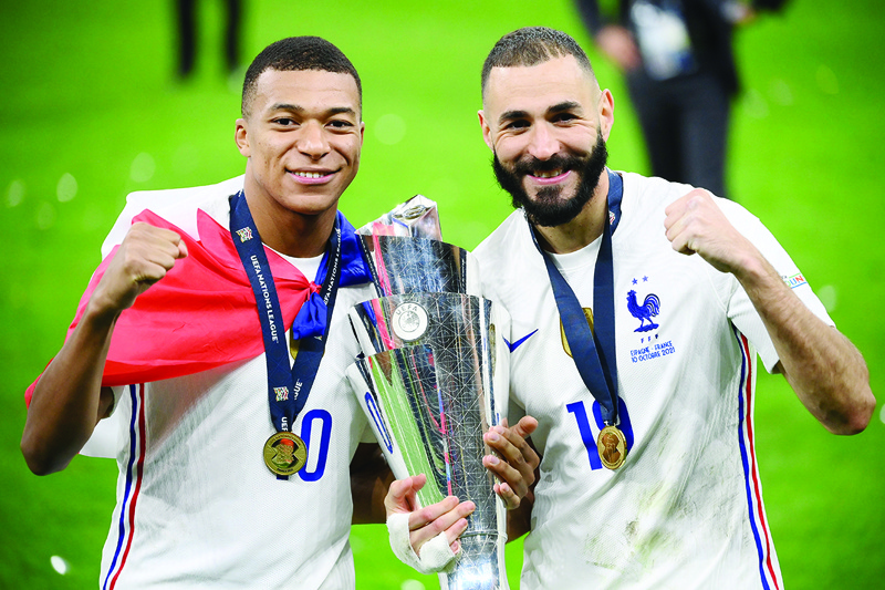 MILAN: France's Kylian Mbappe (left) and Karim Benzema celebrate with the trophy at the end of the Nations League final football match between Spain and France at San Siro stadium in Milan on Sunday. - AFPn