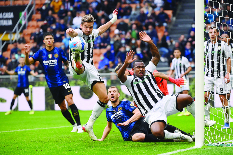 MILAN: Udinese's Danish defender Jens Stryger Larsen clears a ball under pressure from Inter Milan's Bosnian forward Edin Dzeko during an Italian Serie A match at the San Siro stadium yesterday. - AFP n
