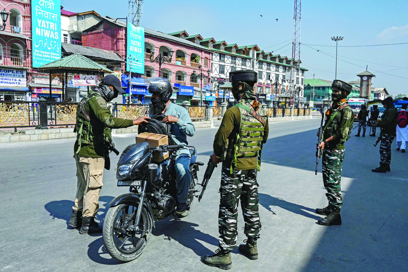 SRINAGAR: A security personnel checks the bag of a motorist along a street in Srinagar, after recent attacks by the suspected anti-India militants in Indian-administered Kashmir. - AFP n