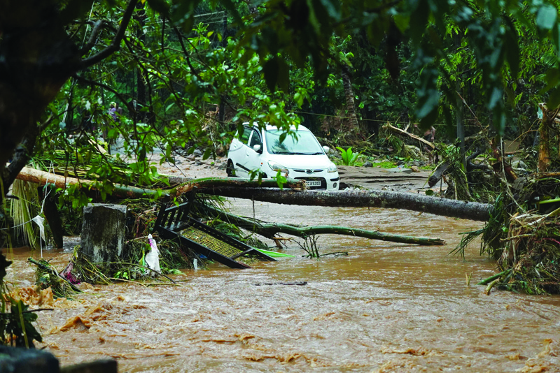 THODUPUZHA: A car stuck in mud waters is pictured after flash floods caused by heavy rains at Thodupuzha in India's Kerala state on October 16, 2021. - AFP n
