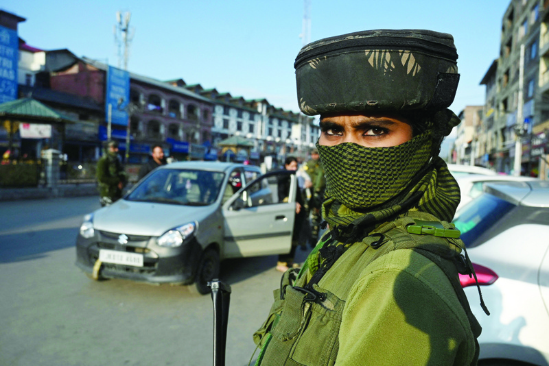 SRINAGAR: A woman paramilitary trooper stands guard during a random search in Srinagar yesterday as security has been beefed-up a day after two laborers from Bihar were killed by gunmen. – AFP n